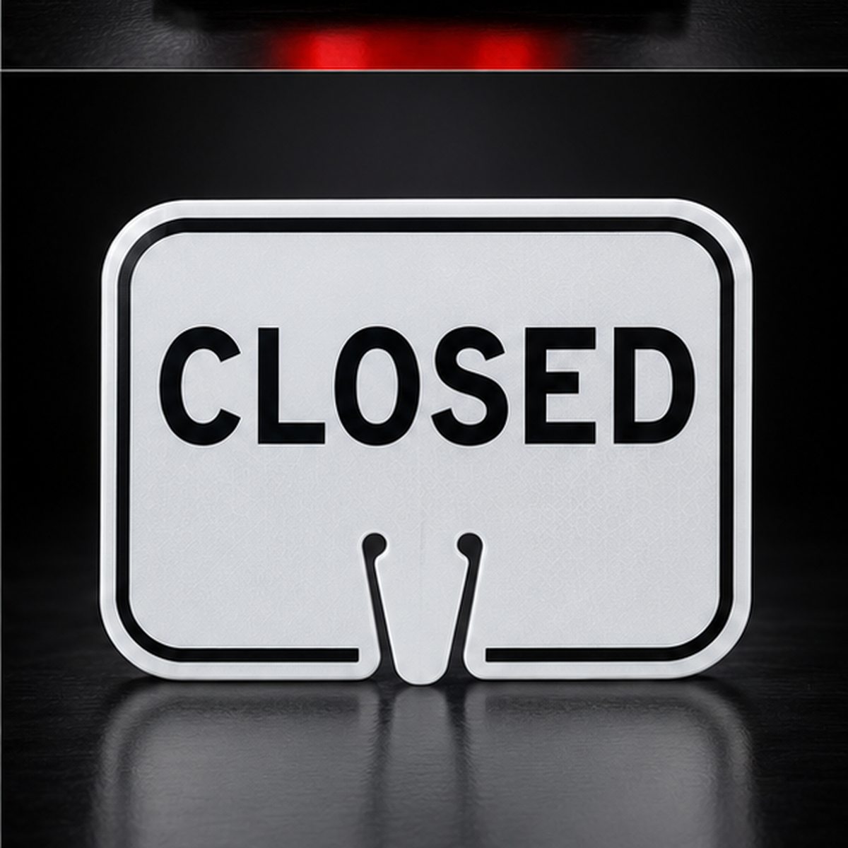 White CLOSED traffic cone sign on black studio background