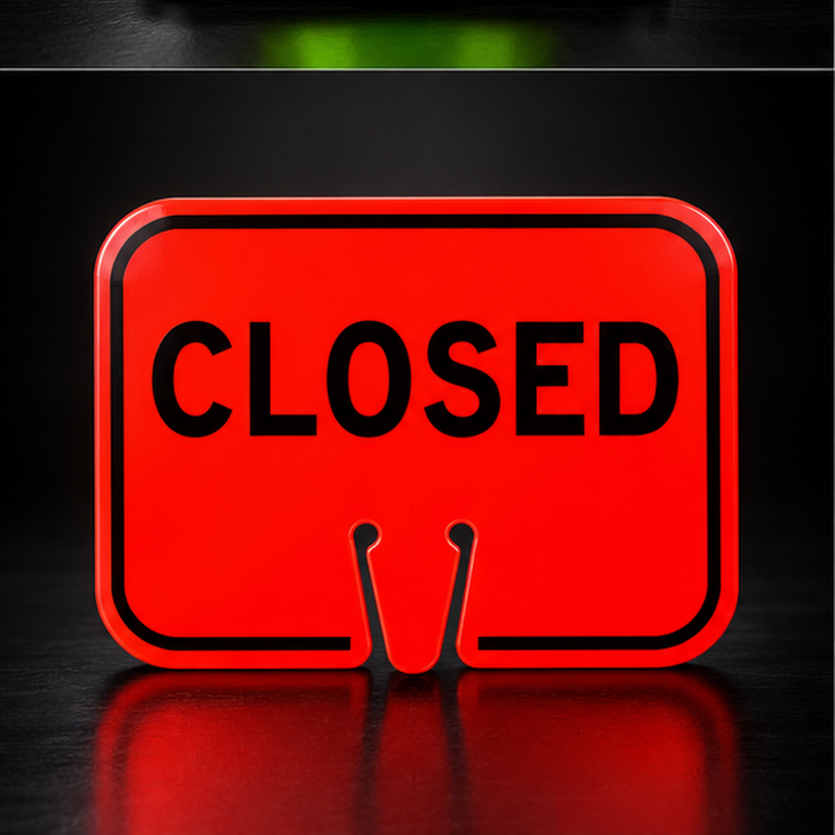 Orange CLOSED traffic cone sign on black studio background
